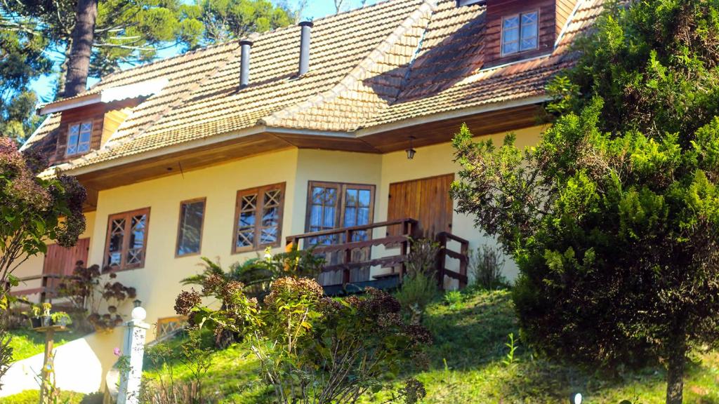 坎波斯杜若尔当德坎普斯 - 杜若尔达奥山林小屋的一座种有树木的山丘上的黄色房子