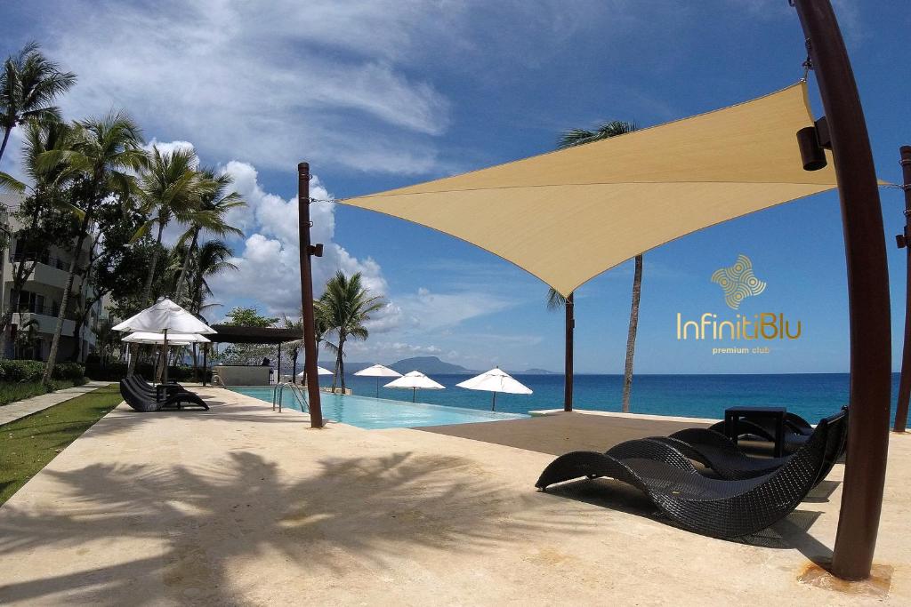 苏莎亚Instyle Residences at Infiniti Blu的一个带大遮阳伞和游泳池的度假村