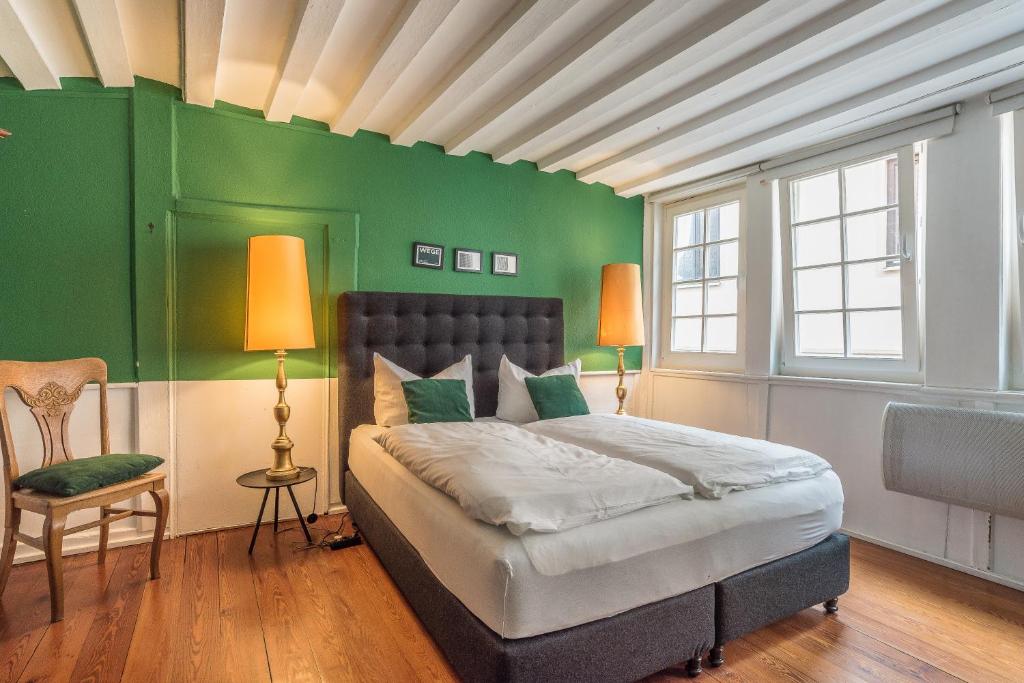 蒂宾根泽特瑞银穆海泽德爱特斯坦德公寓的一间卧室配有一张带绿色墙壁的床