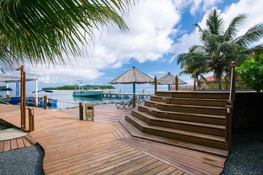Dixon CoveWikkid Resort的木甲板上设有楼梯,水中设有船只