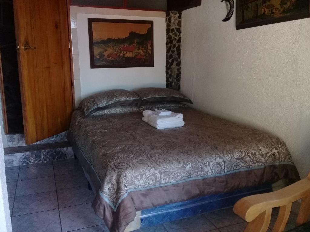 San Antonio PalopóHotel Nuestro Sueño的一间卧室配有一张床,上面有两条毛巾