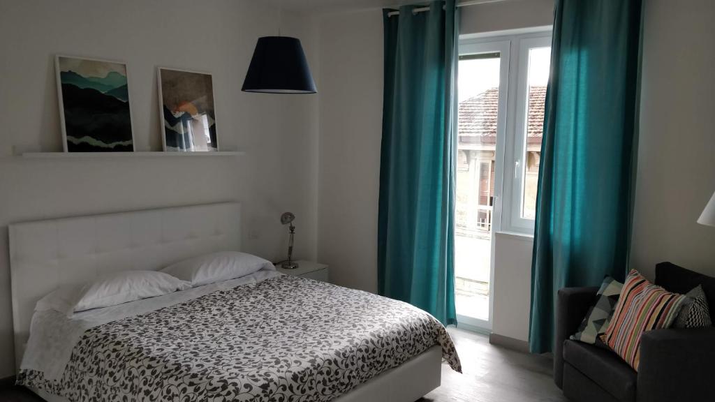 坎波巴索Novantatrè的一间卧室配有一张带蓝色窗帘的床和一扇窗户