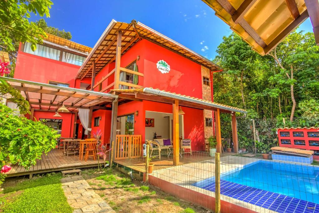 伊塔卡雷i9 Embaú Flats & Suites的一座红色的房子,前面设有一个游泳池