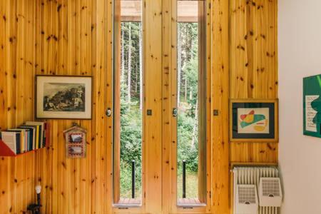 摩德纳迪-坎皮格里奥CENTRAL WOODEN CHALET WITH FOREST VIEW的客房设有木镶板墙和2扇窗户