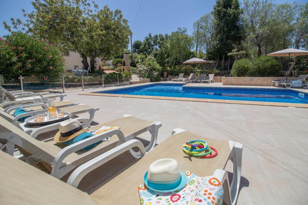 阿尔曼萨Farm of Dreams Algarve的一个带躺椅的游泳池和一张带帽子的桌子