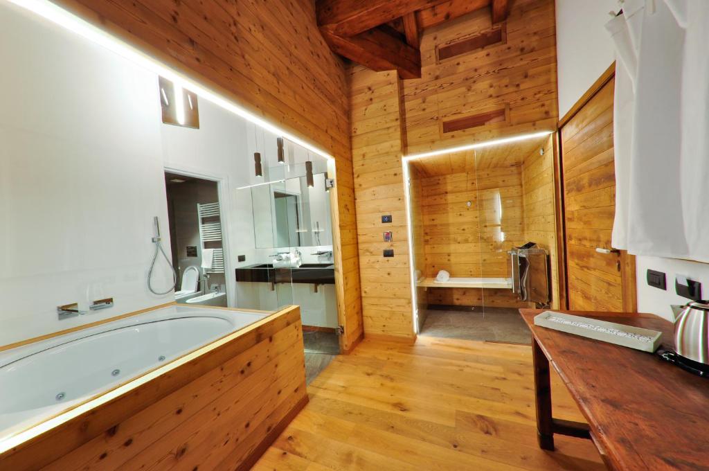 奥斯塔Maison Bionaz Ski & Sport的一间带大浴缸和木墙的浴室