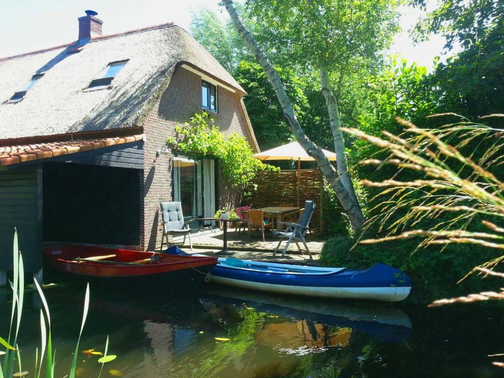 羊角村Giethoorn Lodge的前面水里有两个独木舟的房子