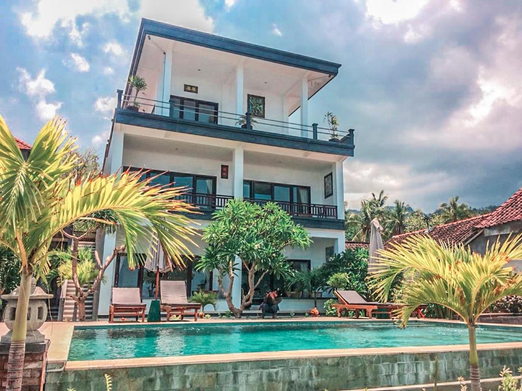 艾湄湾Alam Bali Beach Resort的房屋前有游泳池的房子