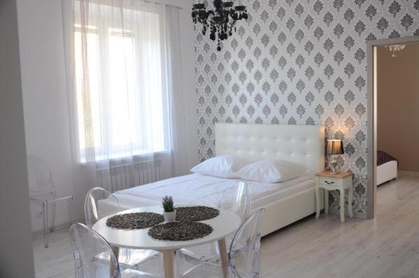 比亚韦斯托克MULTI Apartment Łąkowa 18的卧室配有一张白色的床和桌椅