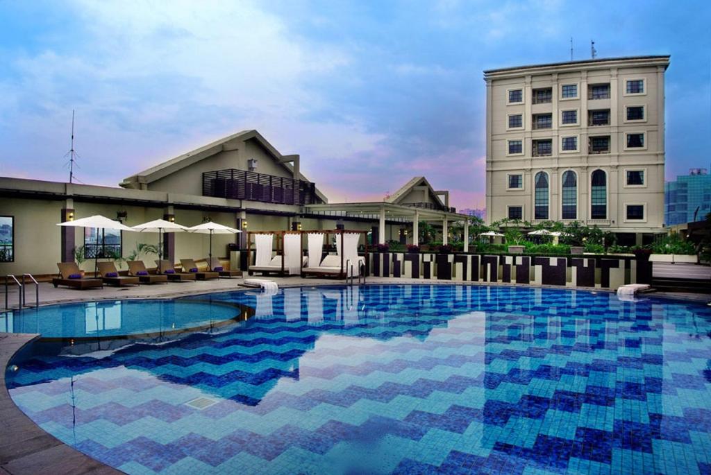 棉兰Grand City Hall Hotel & Serviced Residences的大楼前的大型游泳池
