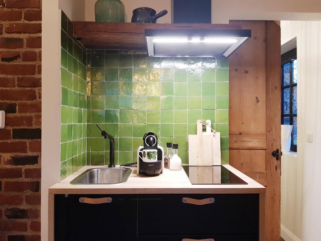 迪尔森-斯托科姆Vakantiehuis ABEL的厨房配有水槽和绿色瓷砖