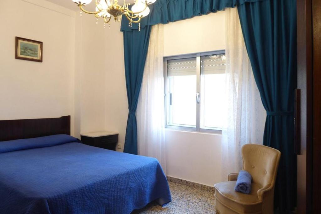 费罗尔El mirador del mar的一间卧室设有蓝色的床和窗户。