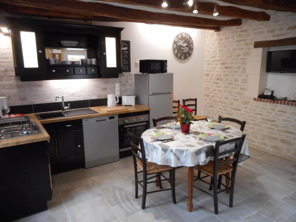 圣艾尼昂GITE DE LA PECHERIE的带桌椅的厨房和带水槽的厨房