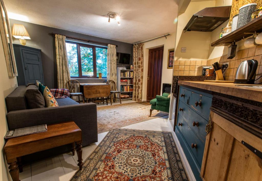 格拉斯顿伯里Dilkara Apartment Glastonbury的厨房以及带沙发和桌子的客厅。