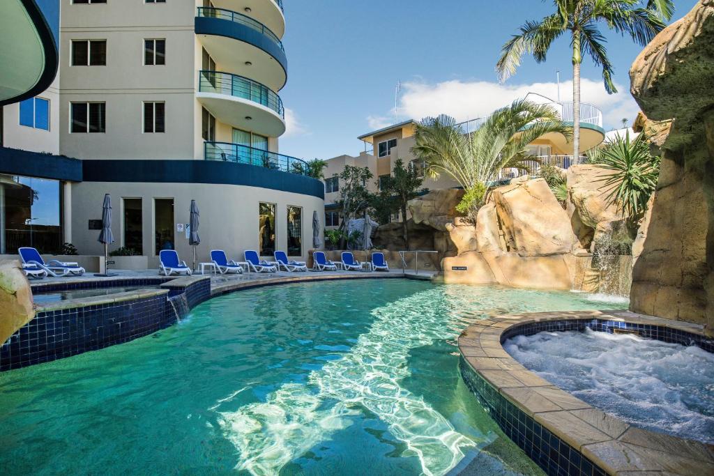 穆卢拉巴地标度假酒店的一座带椅子的度假村游泳池以及一座建筑