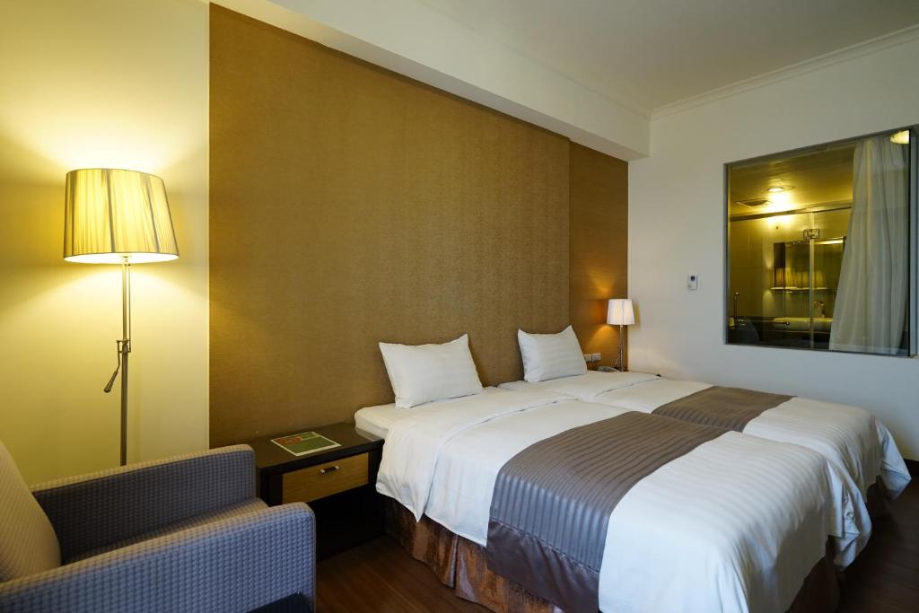马公澎湖海悦饭店的酒店客房带一张大床和一把椅子