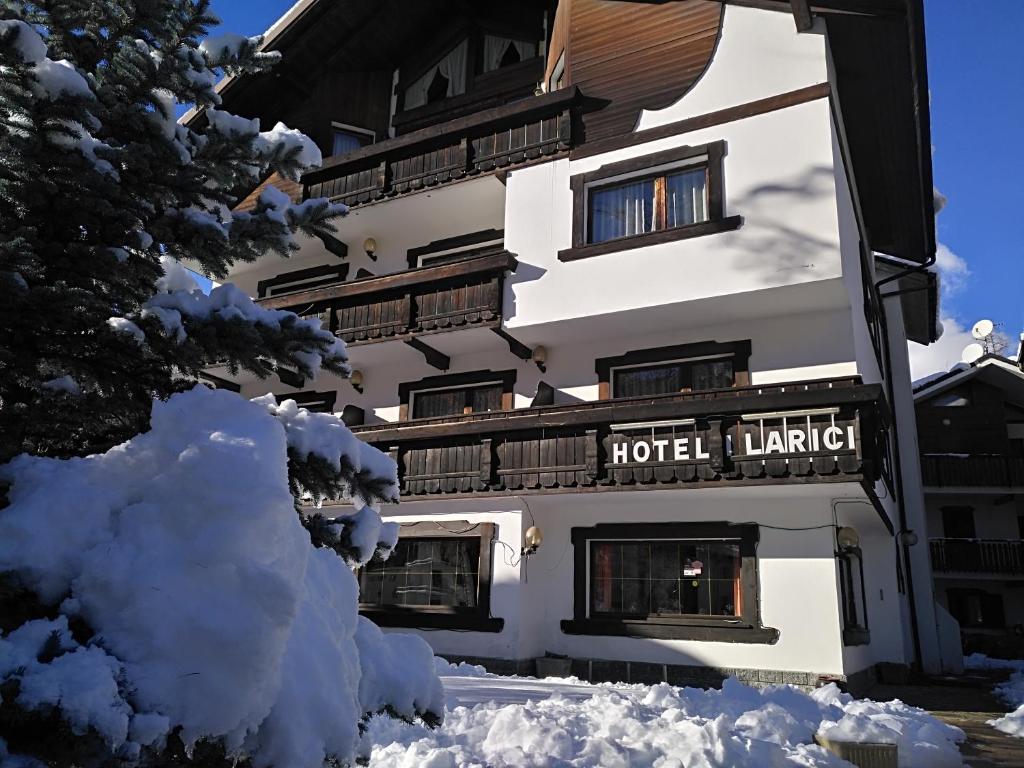 巴多尼奇亚落叶松酒店的前面有雪的酒店大楼
