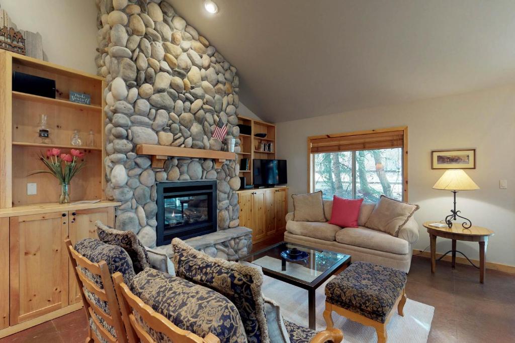 凯彻姆Getaway at The Fields in Warm Springs的客厅设有石制壁炉和沙发。