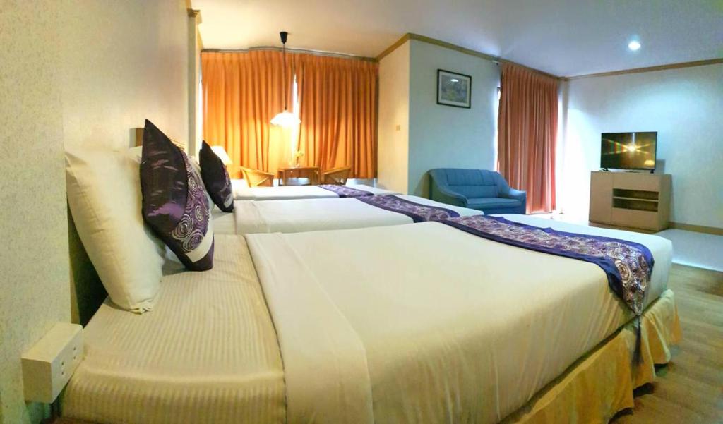 华欣塔卡阿布海滩度假酒店的酒店客房配有一张带枕头的大型白色床。