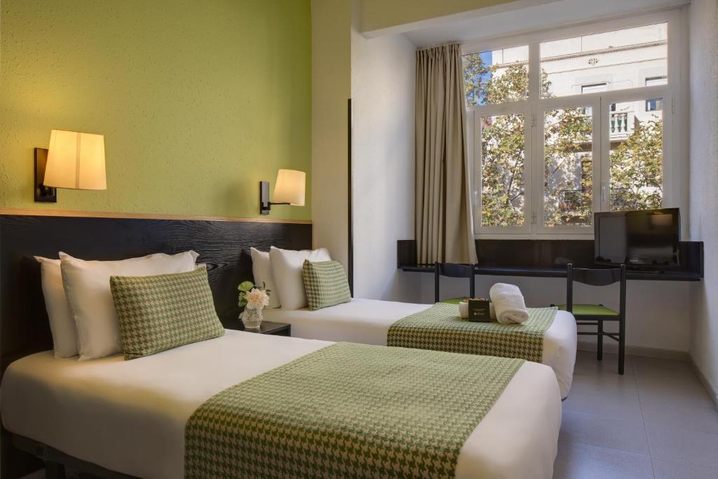 巴塞罗那htop BCN City #htopEnjoy的一间酒店客房,设有两张床和电视
