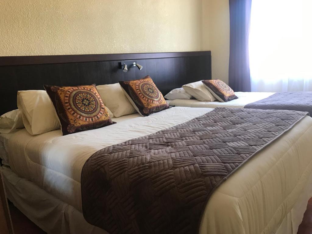 CombarbaláInti Hotel的一间卧室配有两张带枕头的床