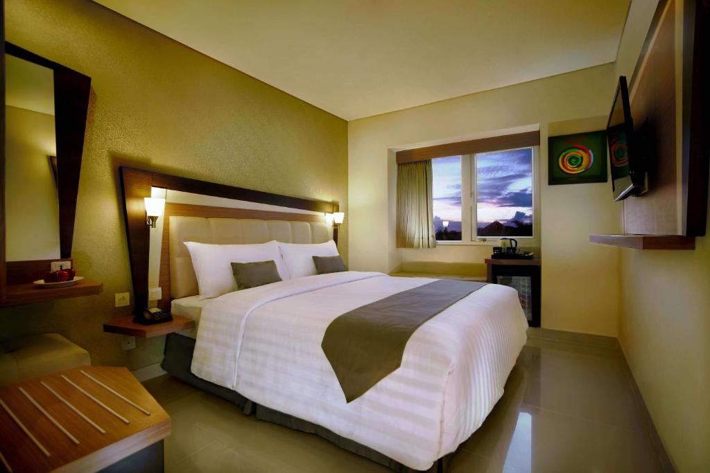 勒吉安捷兰蒂克库塔尼奥酒店的一间设有大床和窗户的酒店客房