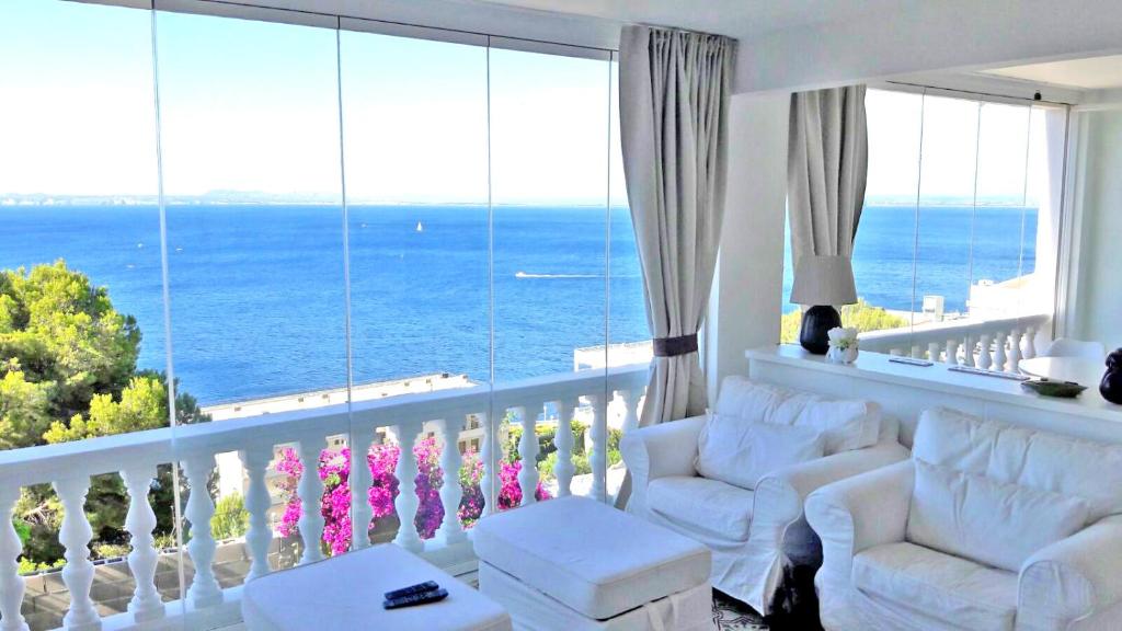 罗萨斯Breathtaking Costabrava seaview apartment 5m beach - Casa ArteVida的一间带白色椅子的客厅和一个海景阳台