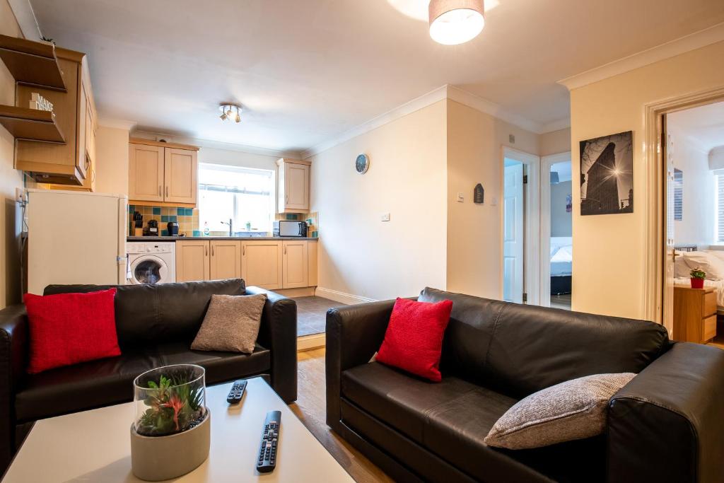 斯丹斯达蒙费雪特Spacious 2BR Flat in Stansted的客厅配有两张真皮沙发和一张桌子