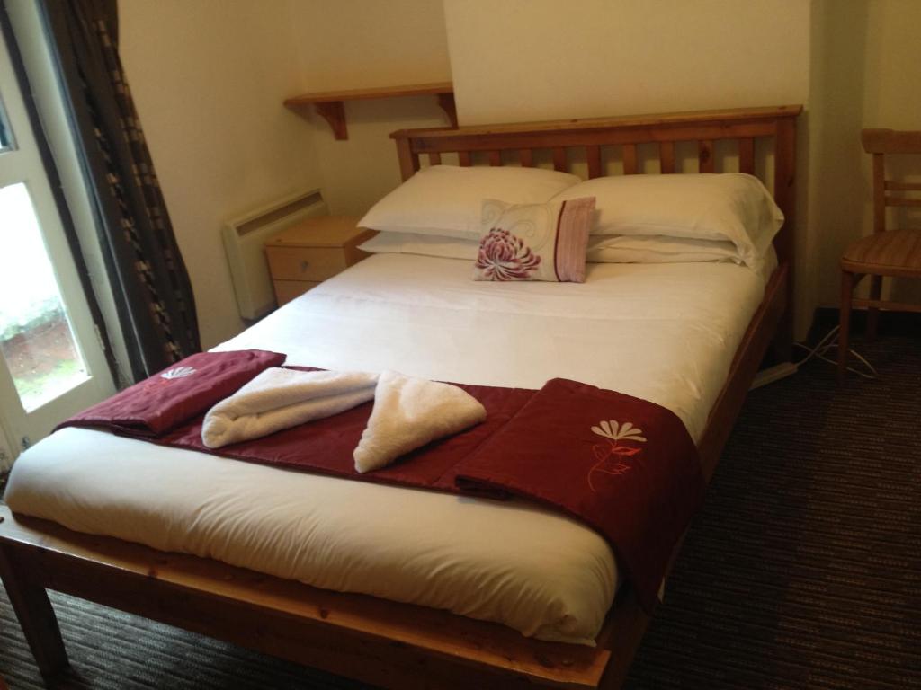 布莱顿霍夫Sandpiper Guest House的一间卧室配有两张带毛巾的床