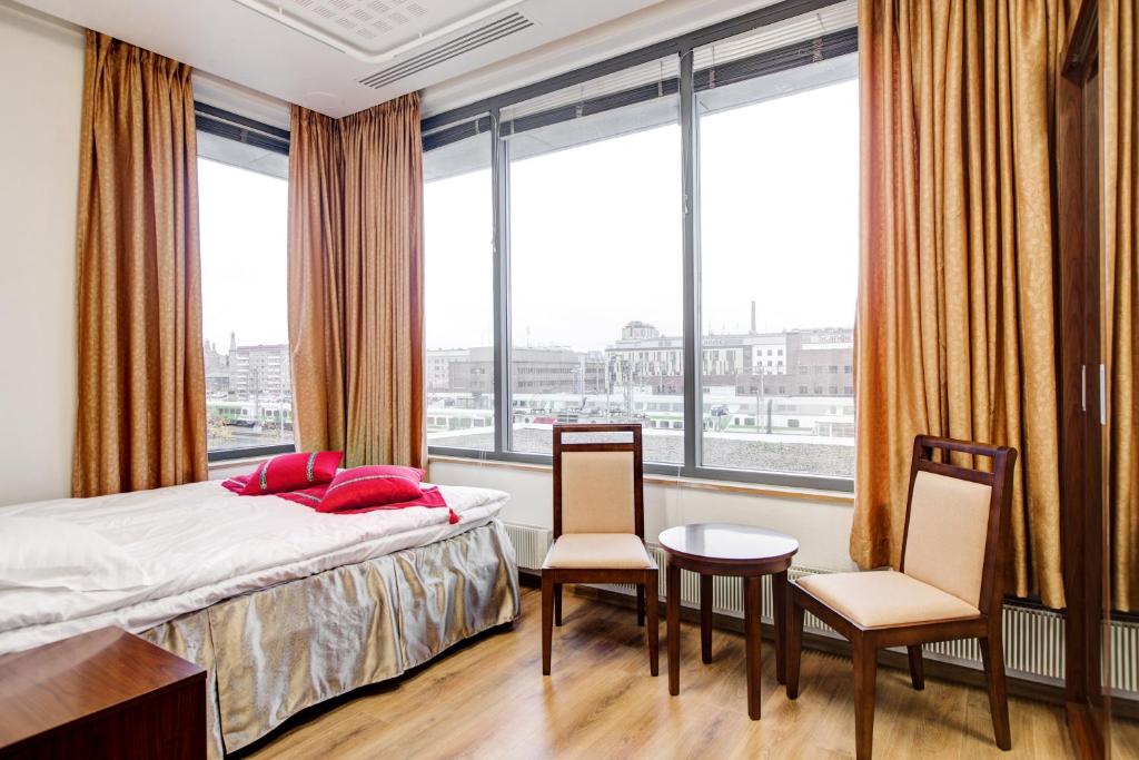 坦佩雷Hotel Citi Inn的一间卧室配有一张床、两把椅子和窗户