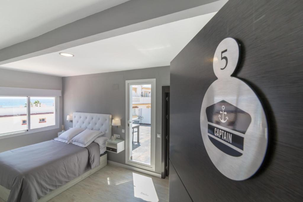 多列毛利诺斯Carihuela Plaza Apartamentos Turisticos的卧室配有一张挂有墙上标志的床
