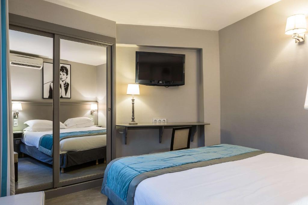 巴黎贝斯特韦斯特蒙加尔姆酒店的酒店客房,设有两张床和镜子