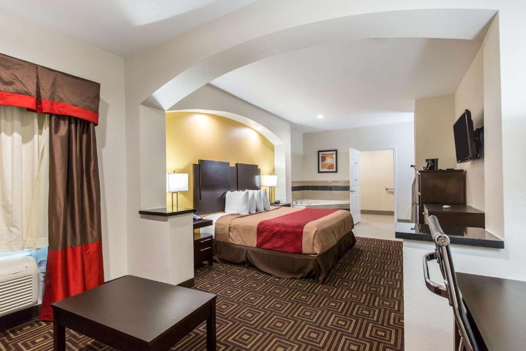 斯普林Scottish Inns & Suites Spring - Houston North的酒店客房配有一张床铺和一张桌子。