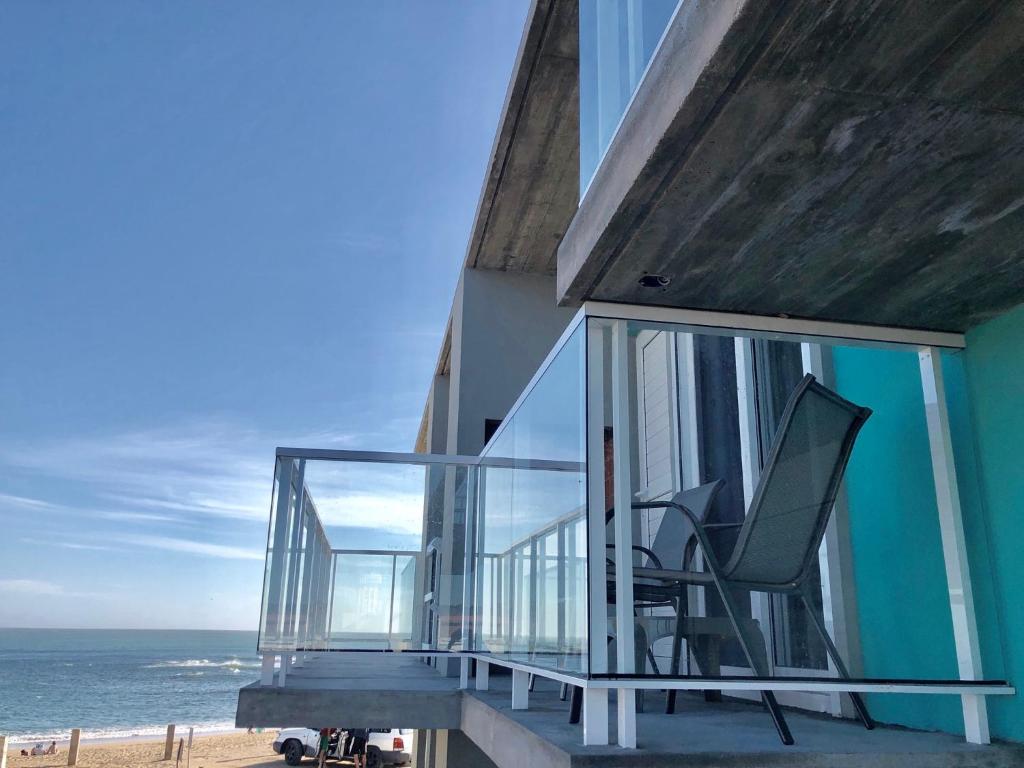 拉帕洛马Las Olas Aparts的海滩上带椅子阳台的房子