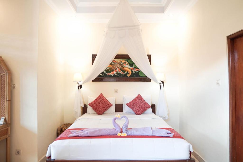 乌布拉卡旅馆的一间卧室配有一张带天蓬的床