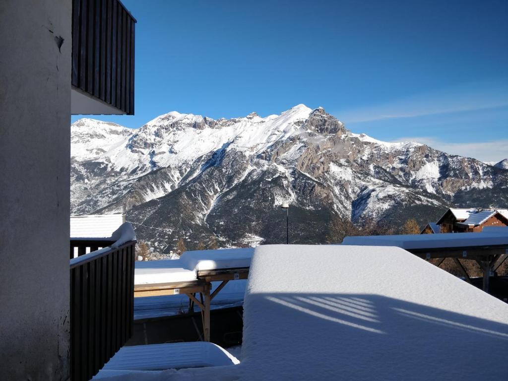 皮伊圣万桑Appartement 4/6 personnes Puy Saint Vincent的阳台享有雪覆盖的山脉美景。