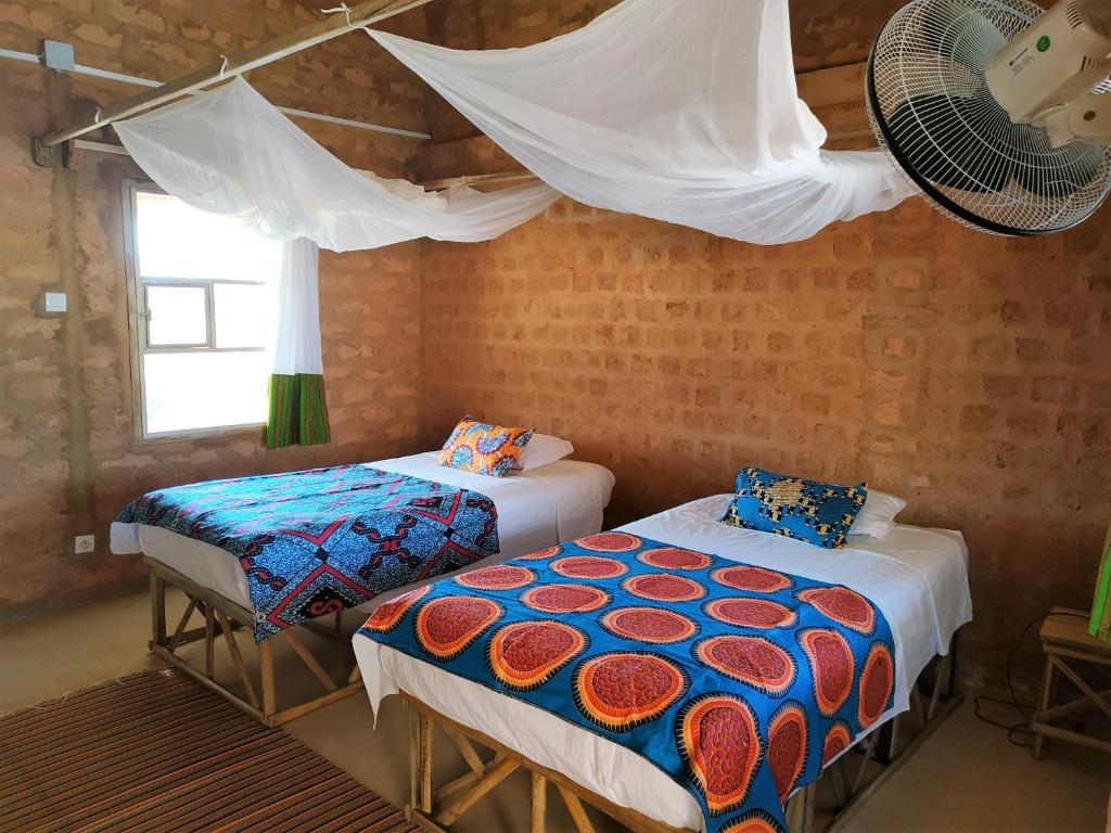 Mar LodjNguel du Saloum - Chez Abdou et Mar的客房设有两张床和风扇。