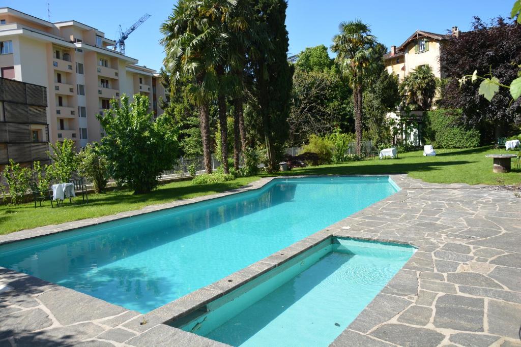卢加诺瑟尔瓦别墅酒店的一座游泳池,位于一座建筑旁的院子内