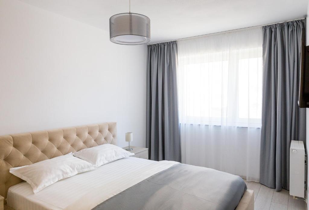 布拉索夫Apartament 4Tourists 2的一间卧室设有一张大床和一个窗户。