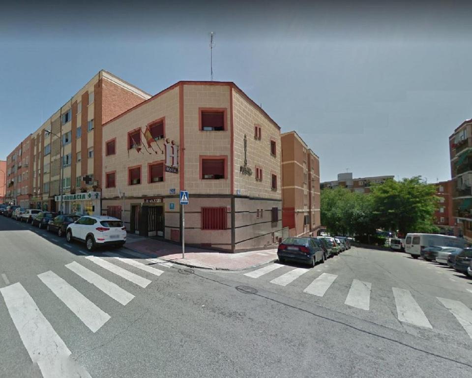 圣塞巴斯蒂安德洛斯雷耶斯若望二十三世旅馆的一条空的街道,汽车停在大楼前