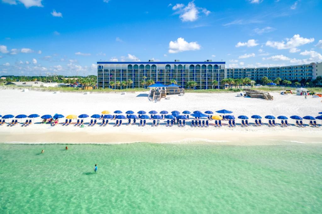 沃尔顿堡滩The Island Resort at Fort Walton Beach的享有海滩和大楼的景色,配有遮阳伞