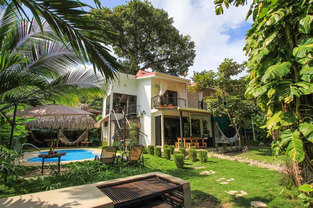 圣塔特蕾莎海滩El Chante Surf House的庭院中带游泳池的房子