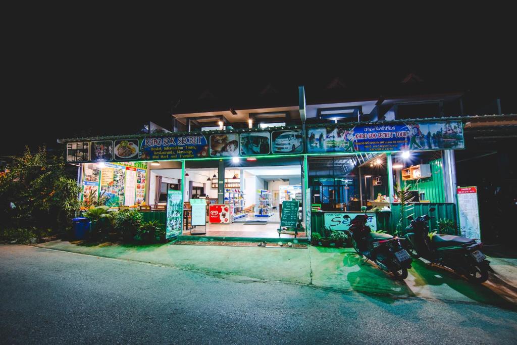 考索Khaosok Secret Hostel的夜间停在商店前面的摩托车
