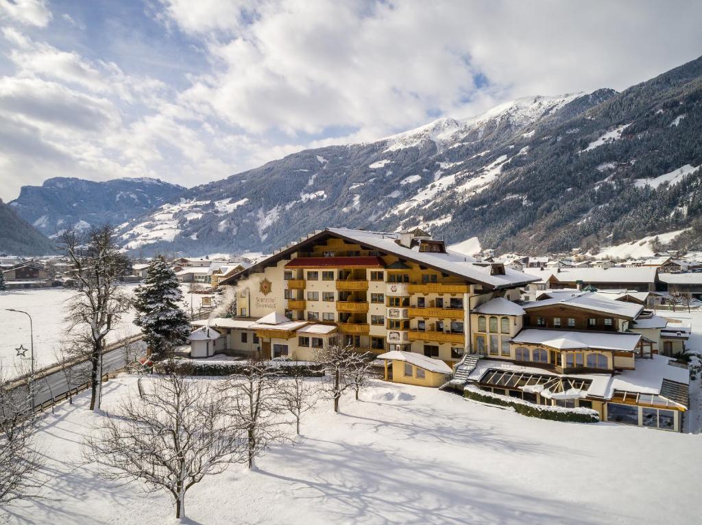 齐勒河谷采尔Ferienhotel Sonnenhof的山底下雪中的酒店