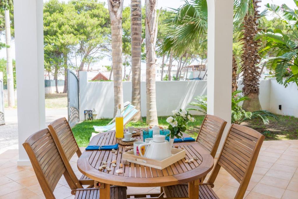 斯培基奥拉Villa Ferreri的棕榈树庭院里的一张木桌和椅子