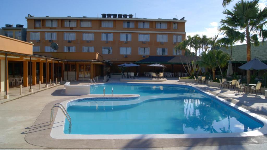 莱蒂西亚Hotel Anaconda的一座酒店游泳池,建筑背景