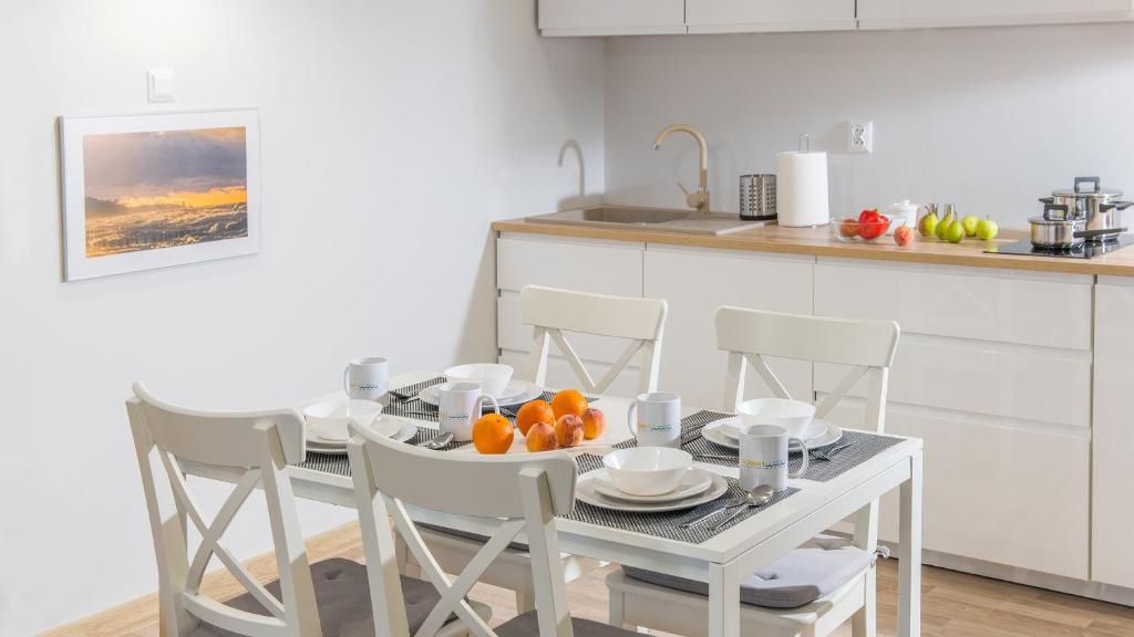 格里兹鲍Piasek i Woda Apartamenty Butikowe的厨房配有带橙子的桌椅