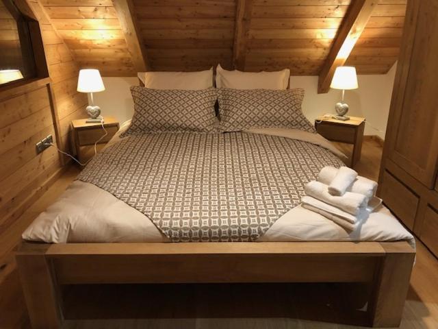 欧龙Chalet La Grange的一间卧室配有一张大床和两盏灯