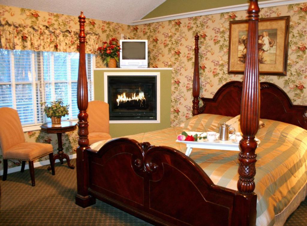 阿夫顿埃弗顿宾馆的一间卧室设有一张天蓬床和一个壁炉