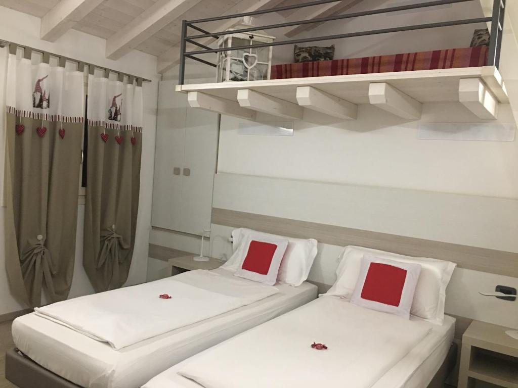 奎托·迪·特雷维索奥斯蒂利亚新住宿加早餐旅馆的配有白色和红色枕头的客房内的两张床